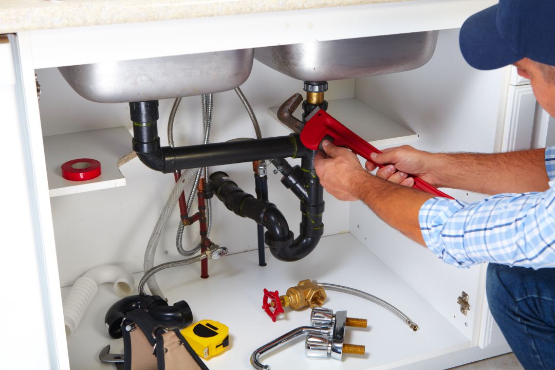 A plumber fiixing the clogged sink.